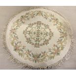 A 4' circular cream rug with flower pattern.