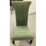 A Victorian high back nursing chair in green upholstery.
