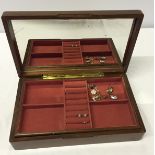 A dark wood rectangular jewellery box with pink interior and mirror.