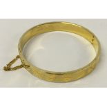 18ct rolled gold bangle with engraved decoration and safety chain.