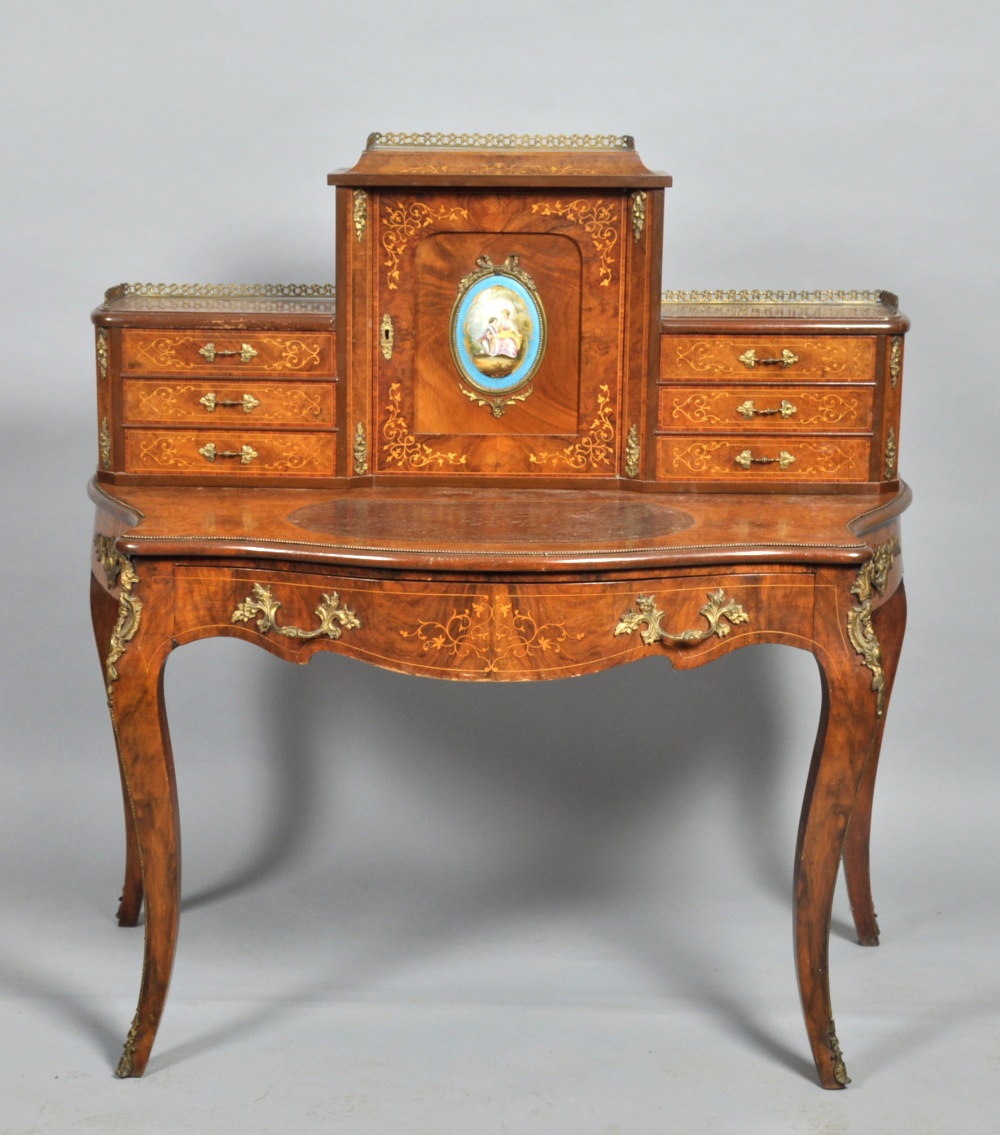 A 19c Louis XV style figured walnut bonheur du jour, the table of serpentine form, the gallery of