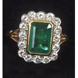 An 18c gold emerald and diamond set ring.