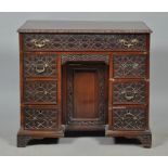 A late Georgian mahogany kneehole desk of rectangular form, the top with lunette and floral carved