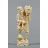 A Meiji period carved ivory figure of a fisherman with a basket of fish on his left shoulder,