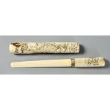 A Meiji period horn paper knife with sheath, the handle carved with birds flying over coastal