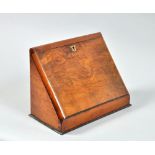 A Victorian figured walnut table top writing cabinet, the hinged cover folding to provide a