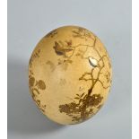 A Meiji period ostrich egg decorated in gilt low relief and mother of pearl and coloured stone