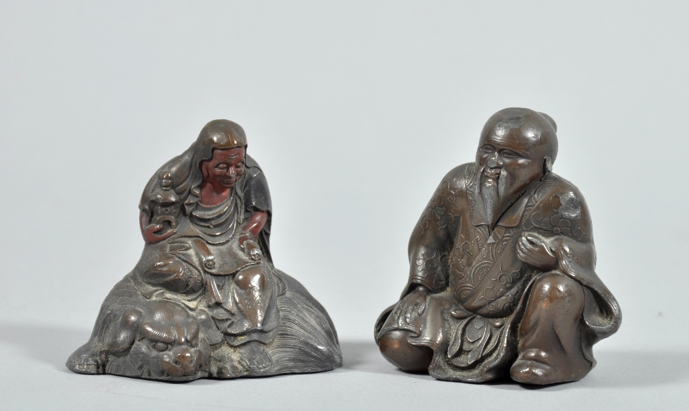 Two patinated and coppered Oriental figures , one seated on a shi-shi, one robed and kneeling,