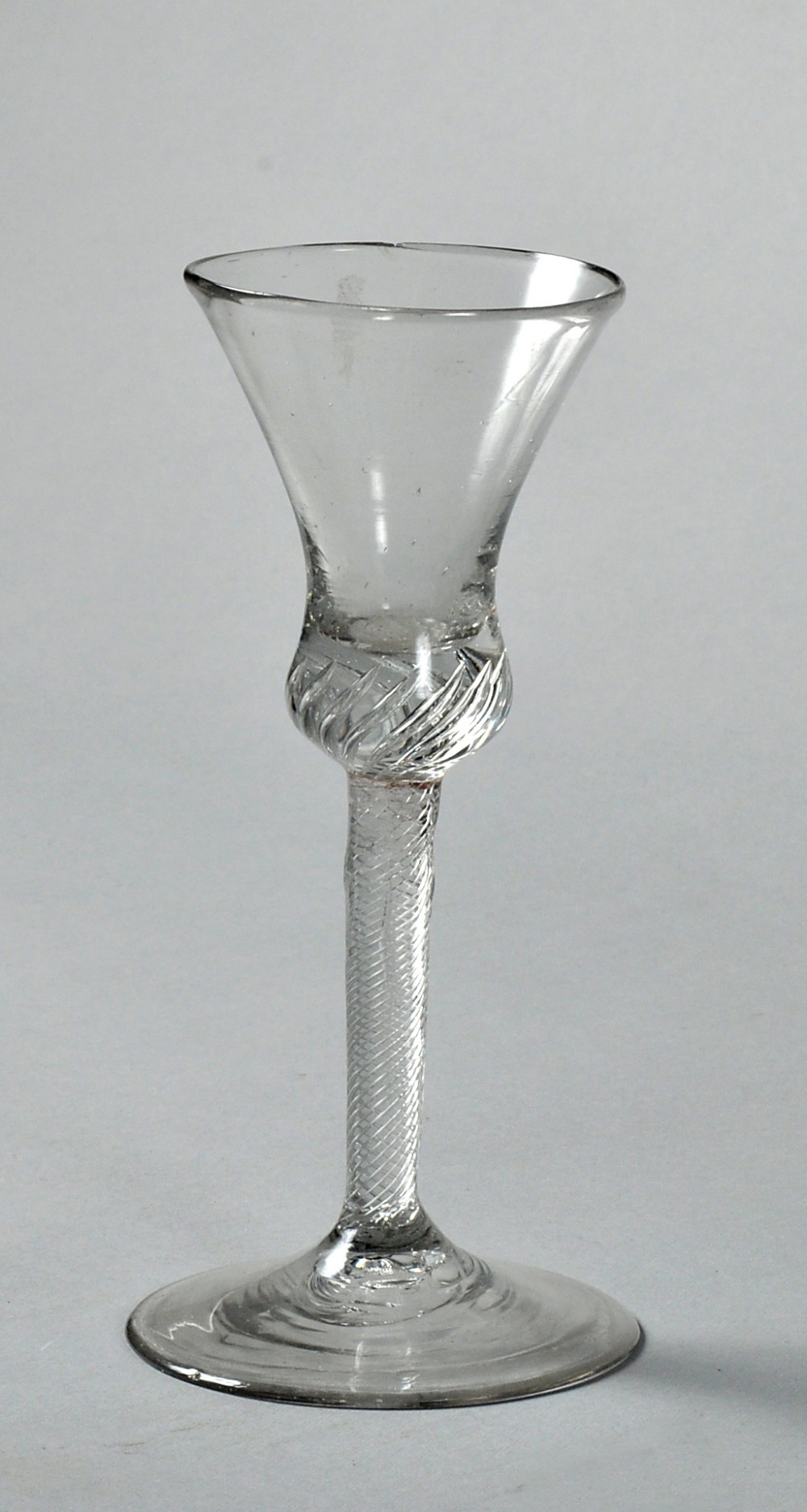 An 18c wine glass with a waisted trumpet bowl, on a clear twisted stem and circular base, a/f