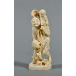 A Meiji period carved ivory figure of a fisherman emptying a basket of fish with a child on his left