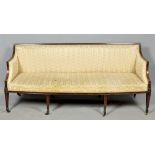 A late Georgian mahogany framed upholstered settee, supported on four rear splayed legs and with