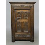 An early 18c oak cabinet of pegged construction , the shelved interior enclosed by a single panelled