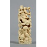 A Meiji period carved ivory figure group of a male and female figure amongst the waves, he riding