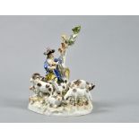A Meissen figure group being a shepherd with his dog and flock of sheep and goats on a rocky mound