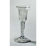 An 18c wine glass with barrel shaped bowl, engraved with trailing leaf and having a white opaque