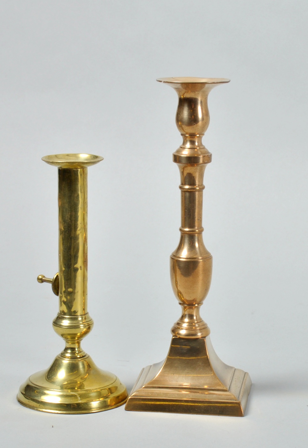 Two 18c candlesticks, one with stepped circular base and with ejector, the other with square stepped