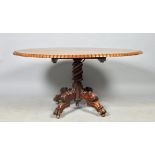 A mid 19c Irish mahogany oval tilt top pedestal breakfast table, the tilt top with carved tooth edge