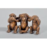 An Oriental wooden okimono carved in the form of three seated monkeys, the base with inscribed