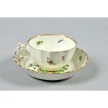 A Worcester cup and saucer of fluted form, decorated in the Kakiemon style with exotic birds,