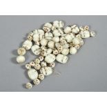 A collection of white ceramic scarab beads and roundels.