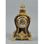 A late 19c French mantel clock in waisted red boullework case with gilded brass feet and mounts