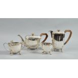 A four piece tea service of faceted angular form, the teapot and water jug with angular composite