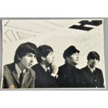 A 1970's mounted photograph of the Beatles, signed by John Lennon in pencil and Ringo Starr in