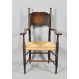 A William Birch Arts & Craft oak framed armchair, with rush seat, slightly curved deep back panel,