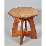 An Arts & Craft oak octagonal centre table supported on four carved panelled legs with cross