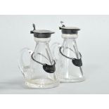 A pair of whiskey water jugs of clear glass and trailed handle with star cut bases, being of