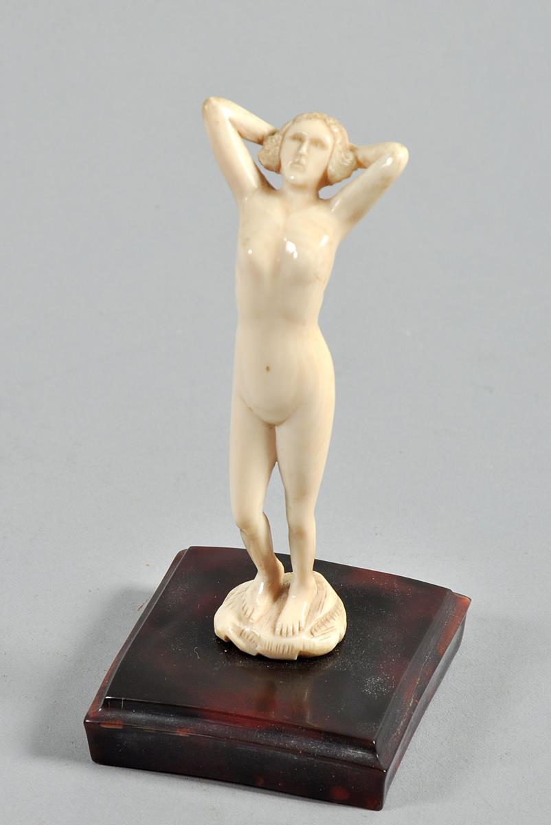 A 1930/40 ivory figure of a naked maiden standing on a rock, on a bakelite base, the figure 4.75"