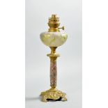 An early 20c brass and marbled columned oil lamp with a frosted glass font, with etched floral