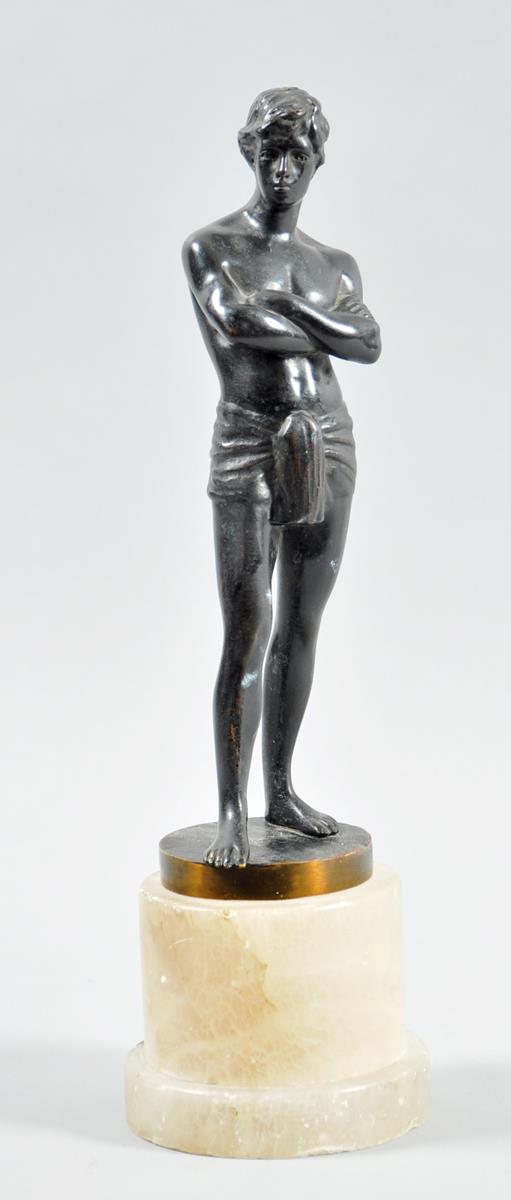 A patinated bronze figure of a young man wearing a loin cloth, supported on an alabaster base, the