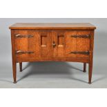 A William Birch Arts & Craft two door oak sideboard, with copper strap hinges with tapered legs