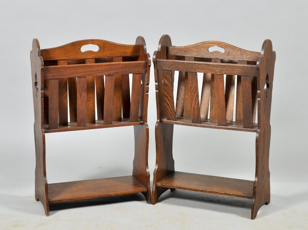 A pair of Arts & Craft style oak magazine racks with slatted divisions, pierced handles, panelled