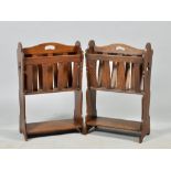 A pair of Arts & Craft style oak magazine racks with slatted divisions, pierced handles, panelled