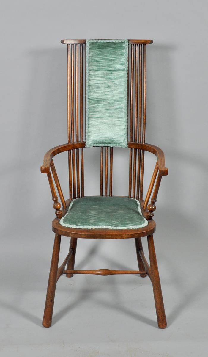 A late 19c/early 20c Arts & Craft spindle back bow armchair with shaped seat and supported on