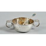 A Liberty & Co porringer and spoon. The porringer with rim extended and finger ring handles,