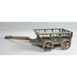 A Victorian painted pine dolls cart with pull-along handle and iron wheels, painted green with