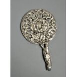 An Oriental silver hand mirror with flower bud and leaf decoration, having a twig handle, 10"w.