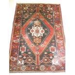 An Eastern hand knotted wool rug with geometric decoration on red and blue ground 62" x 45"