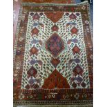 An Eastern hand knotted wool rug with bird, animal and geometric decoration on red and cream