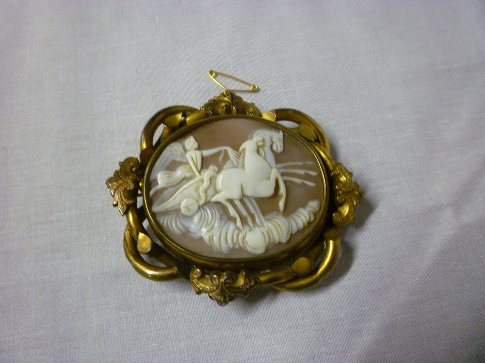 A large Victorian oval cameo mourning brooch, the central panel decorated with a winged figure in