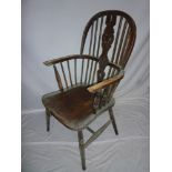 An old elm and beech Windsor-style armchair with spindle and splat back, shaped seat on turned