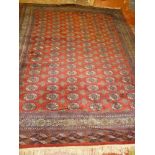A 20th century Eastern hand knotted Bokhara carpet with multiple medallion decoration on red