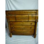 A large mid-Victorian figured mahogany chest of drawers in two parts comprising a long curved frieze