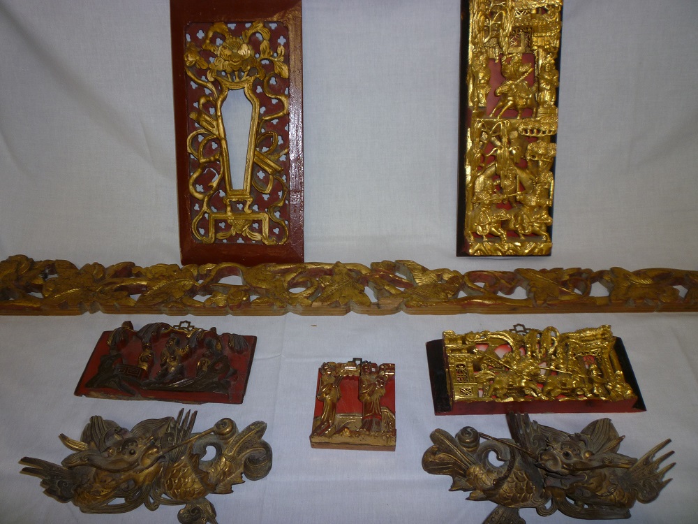 A selection of Chinese carved wood figures and ornamentation including a pair of gilt decorated fish