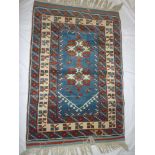 An Eastern hand knotted wool rug with geometric decoration on blue ground 48" x 34"