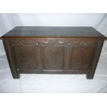 An 18th century and later carved oak rectangular coffer with triple panelled front and hinged lid