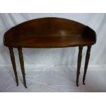 An early 19th century and later mahogany bow front serving table with arched back on six turned